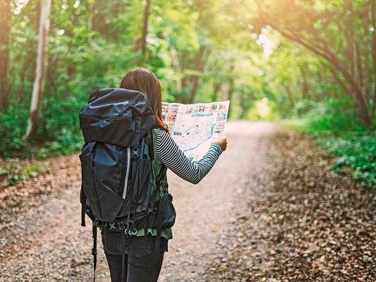 a lady reading a map in the forest