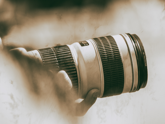 A camera lens on a camera in black and white